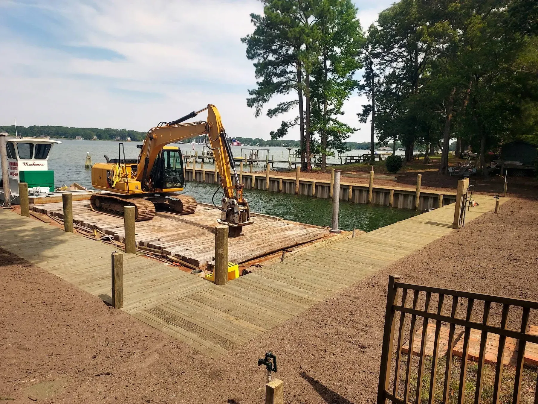 Excavator barge beside a new pier and bulkheaded yard