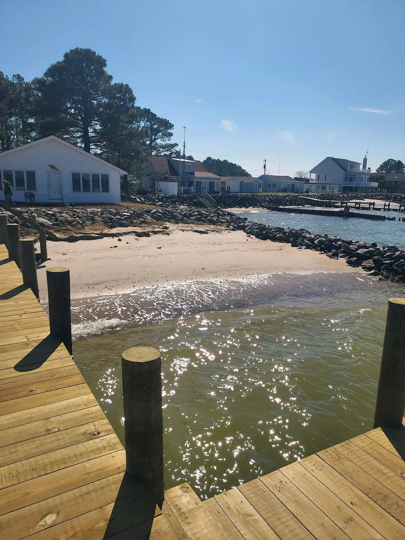 Pier over clear water off a sandy beach