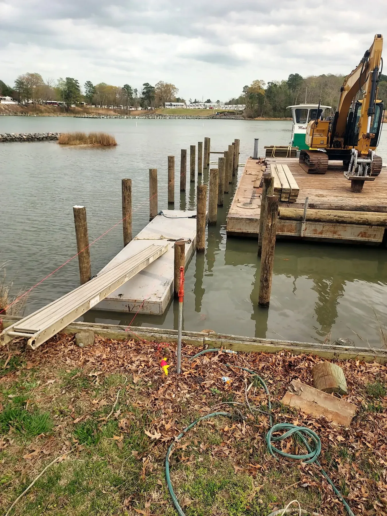 Barge and excavator building a pier on a creek