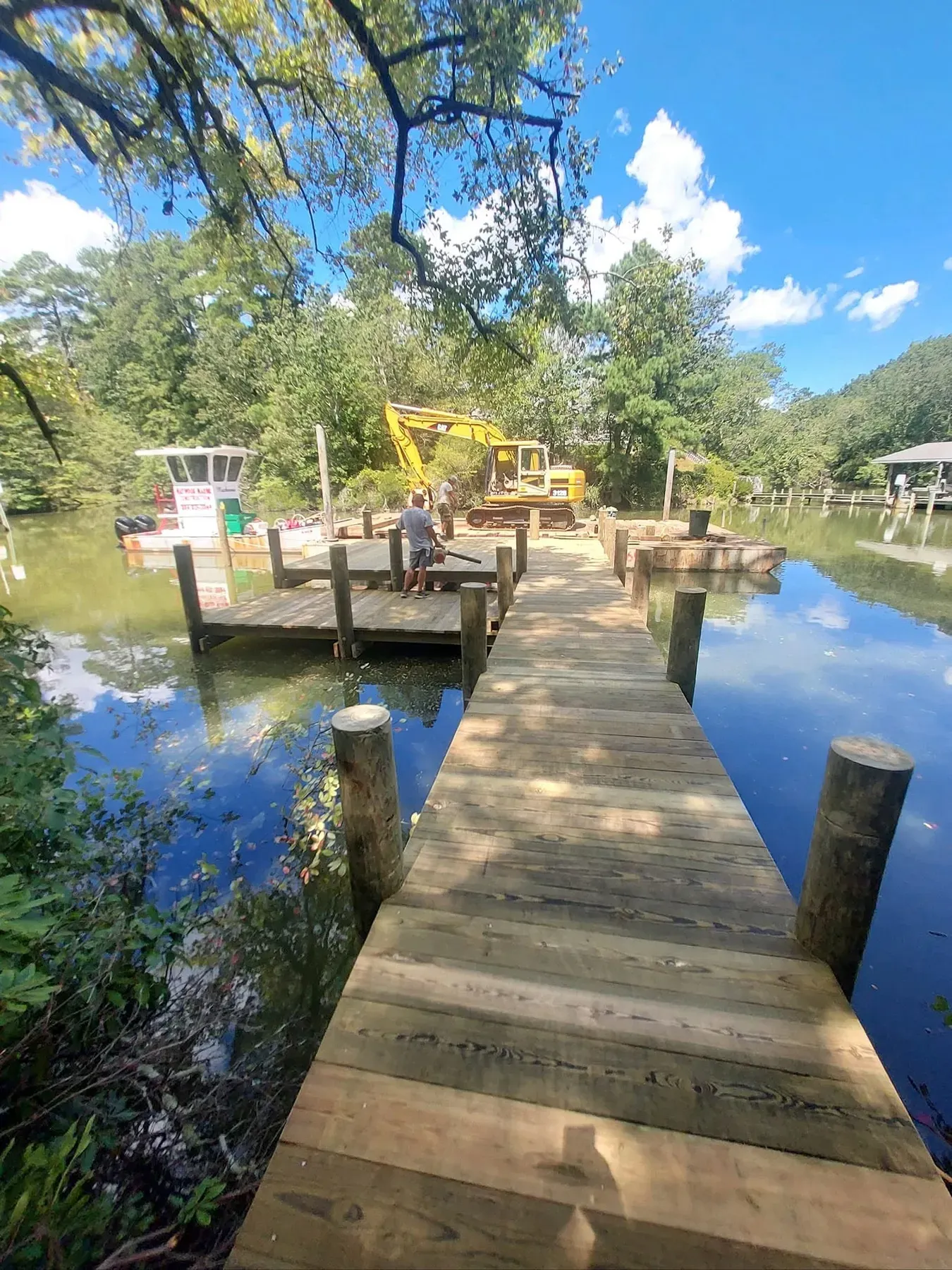 Pier running into a narrow tree-lined creek